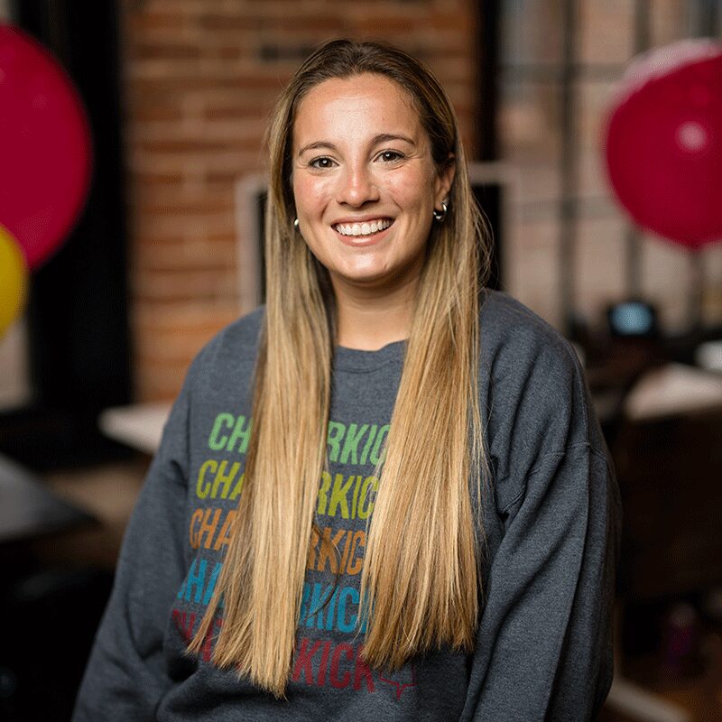 Aileen wearing a grey crewneck sweater with Chatterkick logos